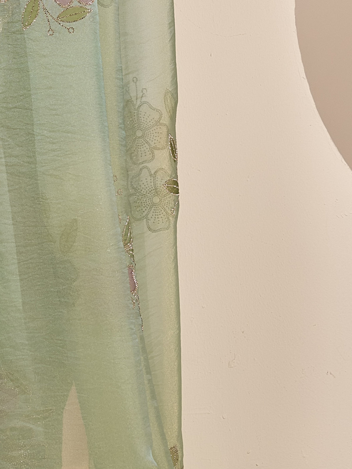 Pallu detail of sea green organza saree showing ornamented surface design and scallop border