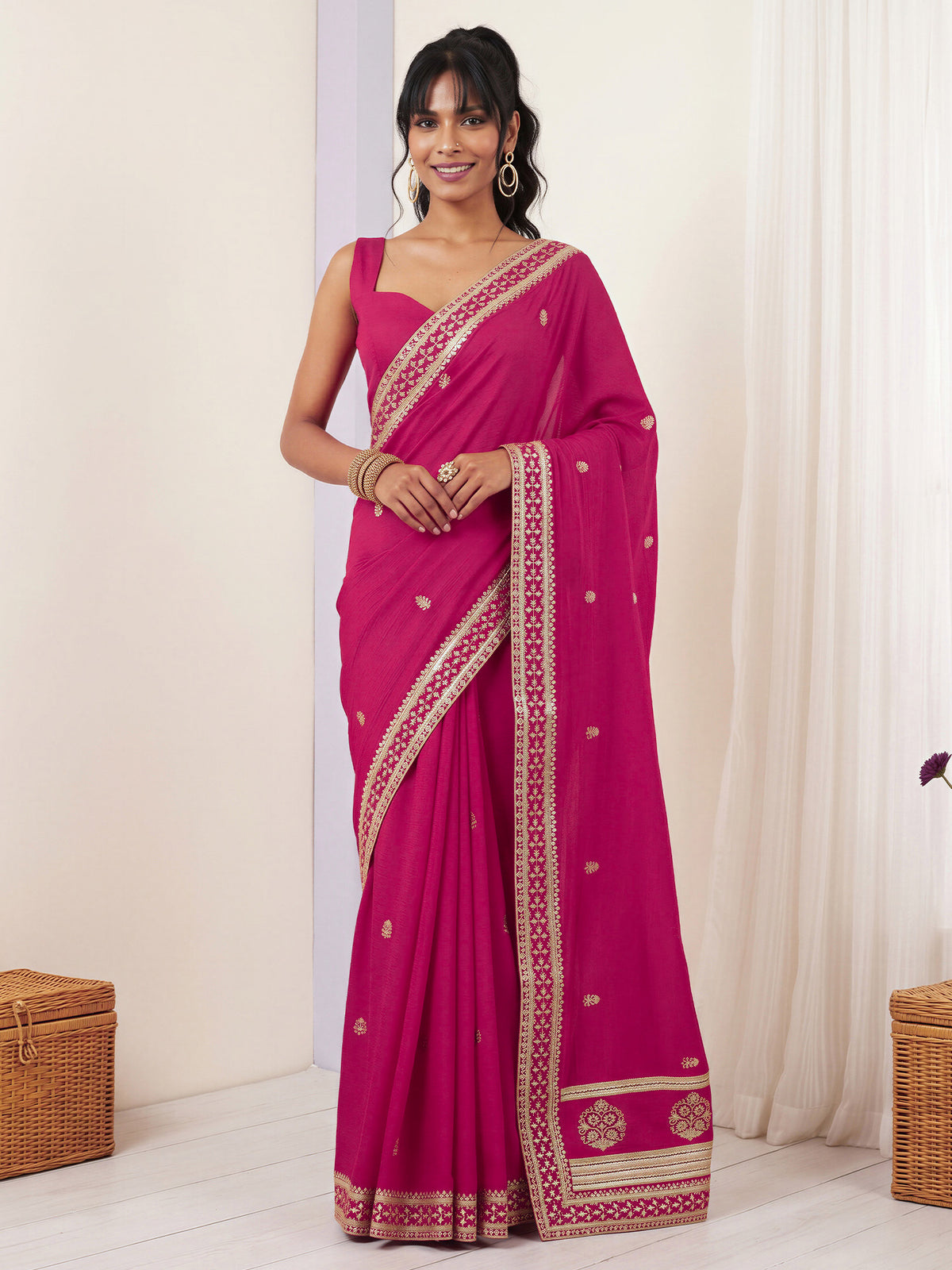 Woman wearing pink vichitra silk saree with embroidered motif work and pink blouse