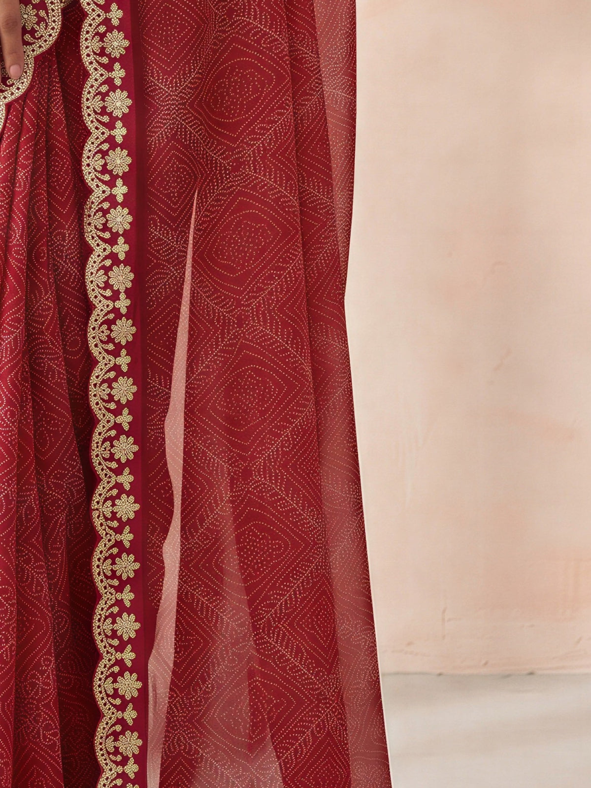 Pallu detail of pink georgette saree showing bandhani tie-dye dot work and embellished border
