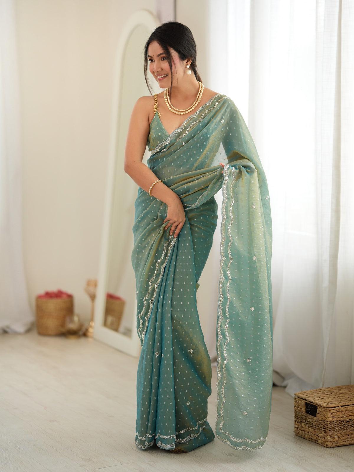 Woman wearing light blue georgette saree with zari butta (metallic motif) work and light blue blouse