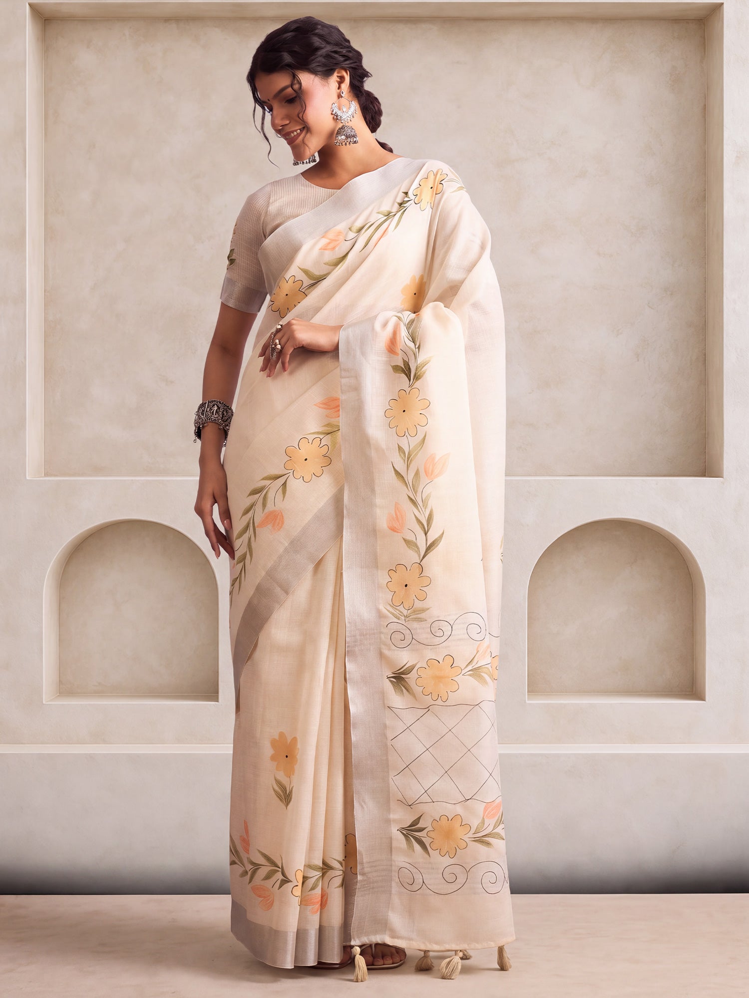 Woman wearing beige linen saree with traditional indian motif work and beige blouse