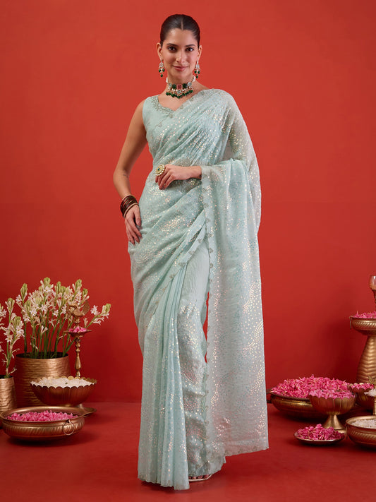 Woman wearing light blue satin saree with ornamented surface design and light blue blouse