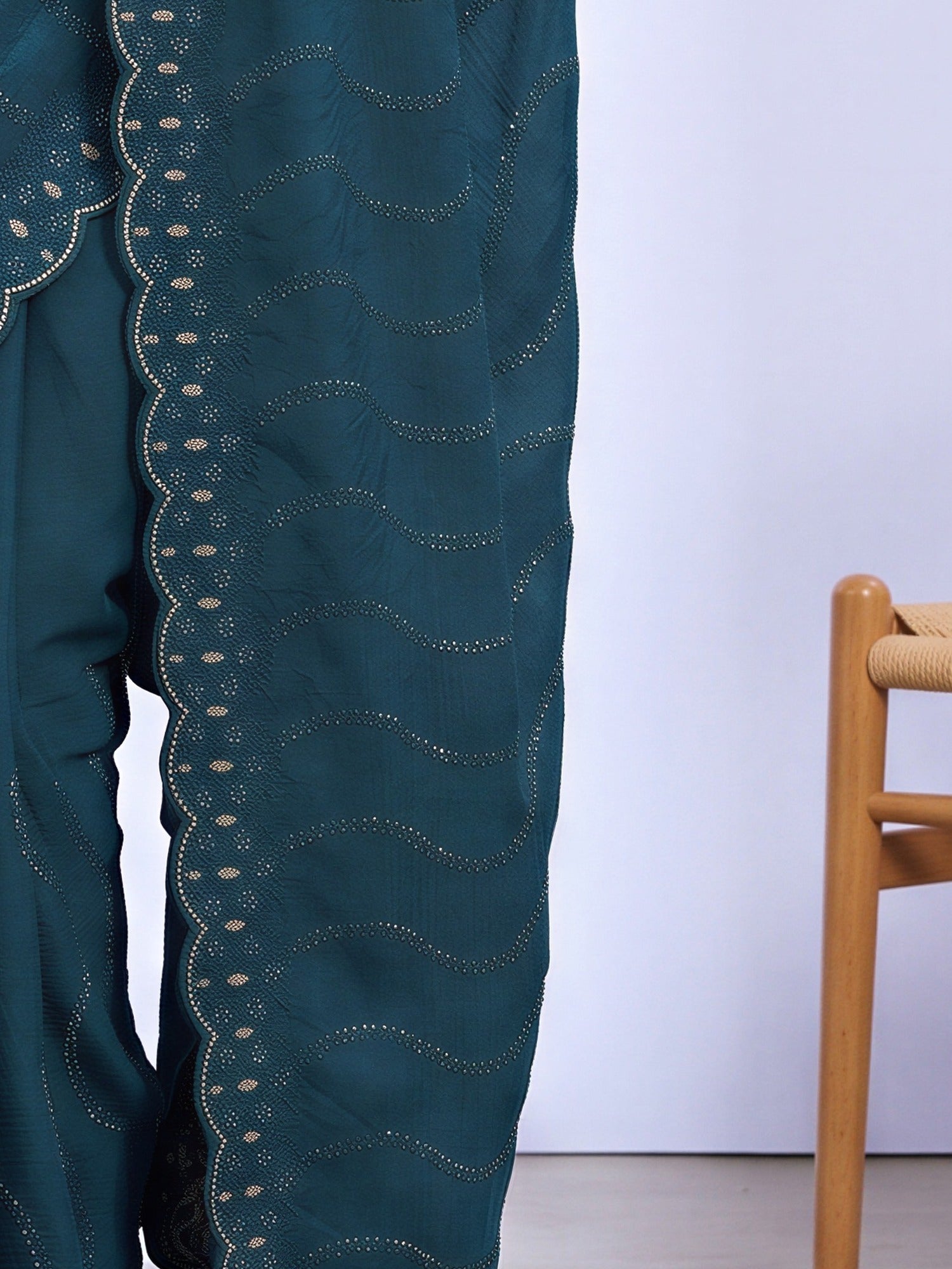 Pallu detail of teal blue tissue saree showing geometric pattern design and embellished border