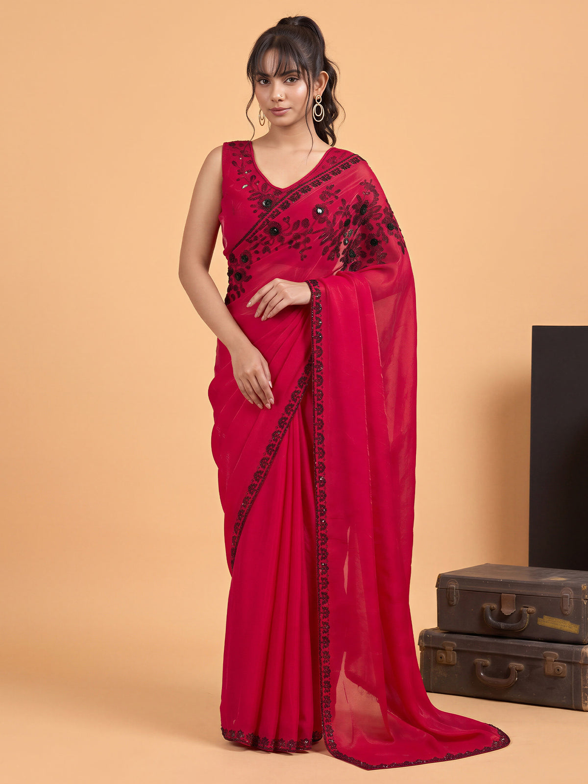 Woman wearing pink satin silk saree with ornamented surface design and pink blouse