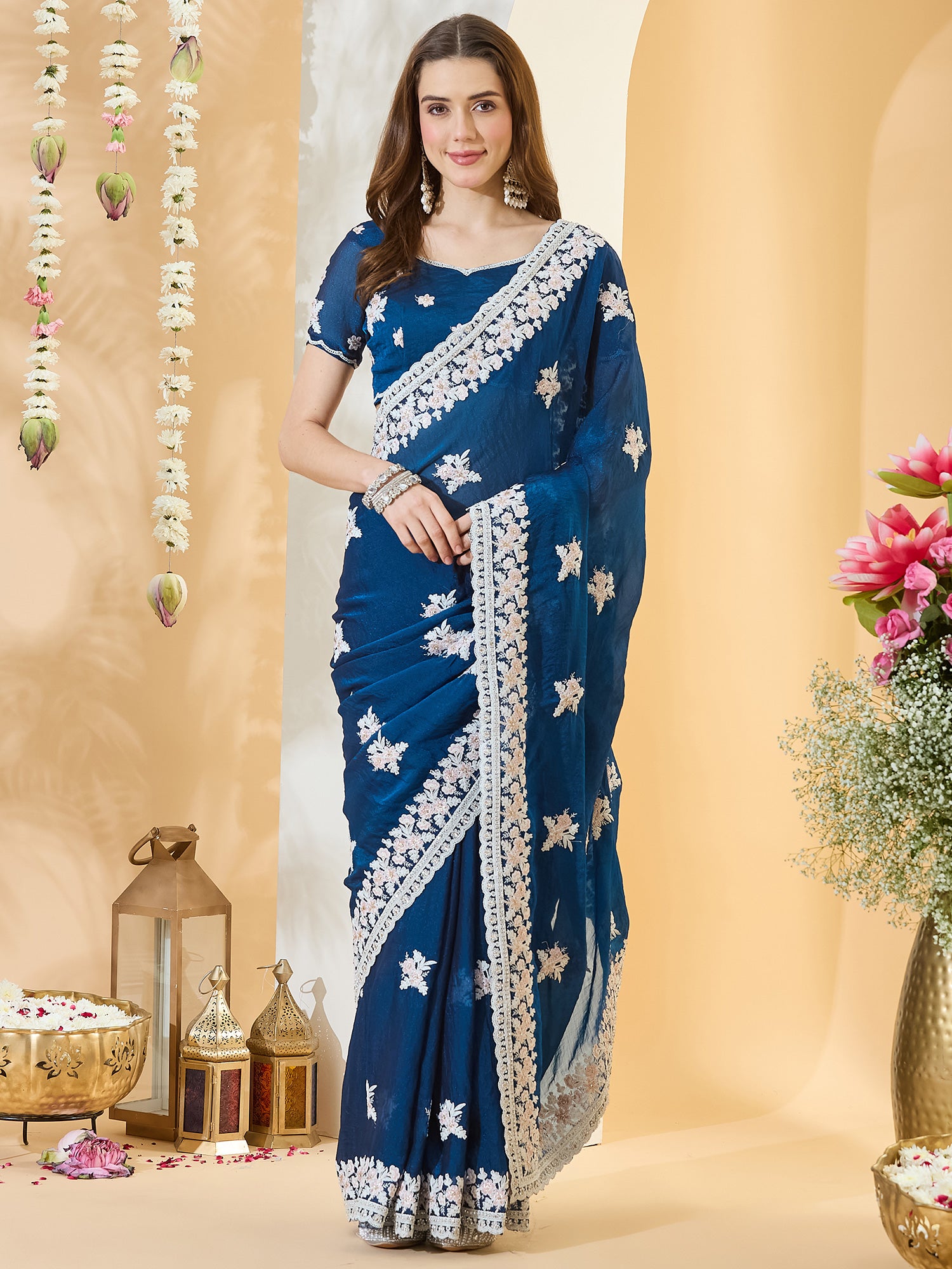 Woman wearing teal blue georgette saree with embroidered motif work and teal blue blouse