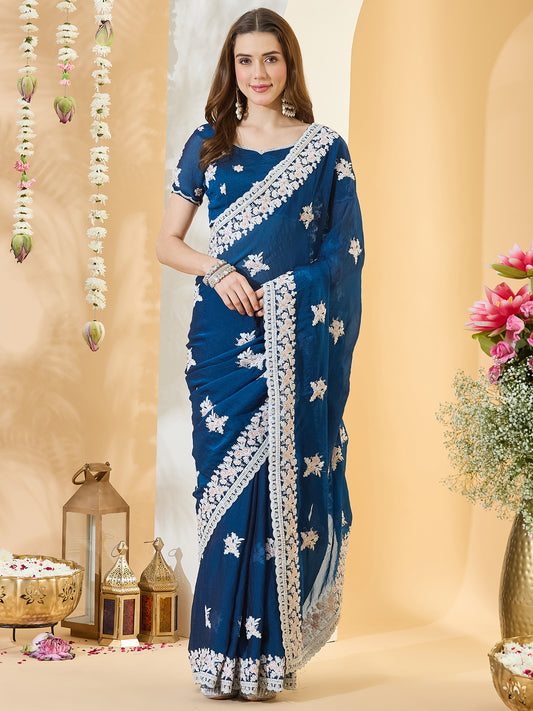 Woman wearing teal blue georgette saree with embroidered motif work and teal blue blouse