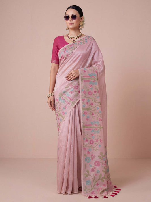 Woman wearing pink tissue saree with all-over floral design and magenta blouse
