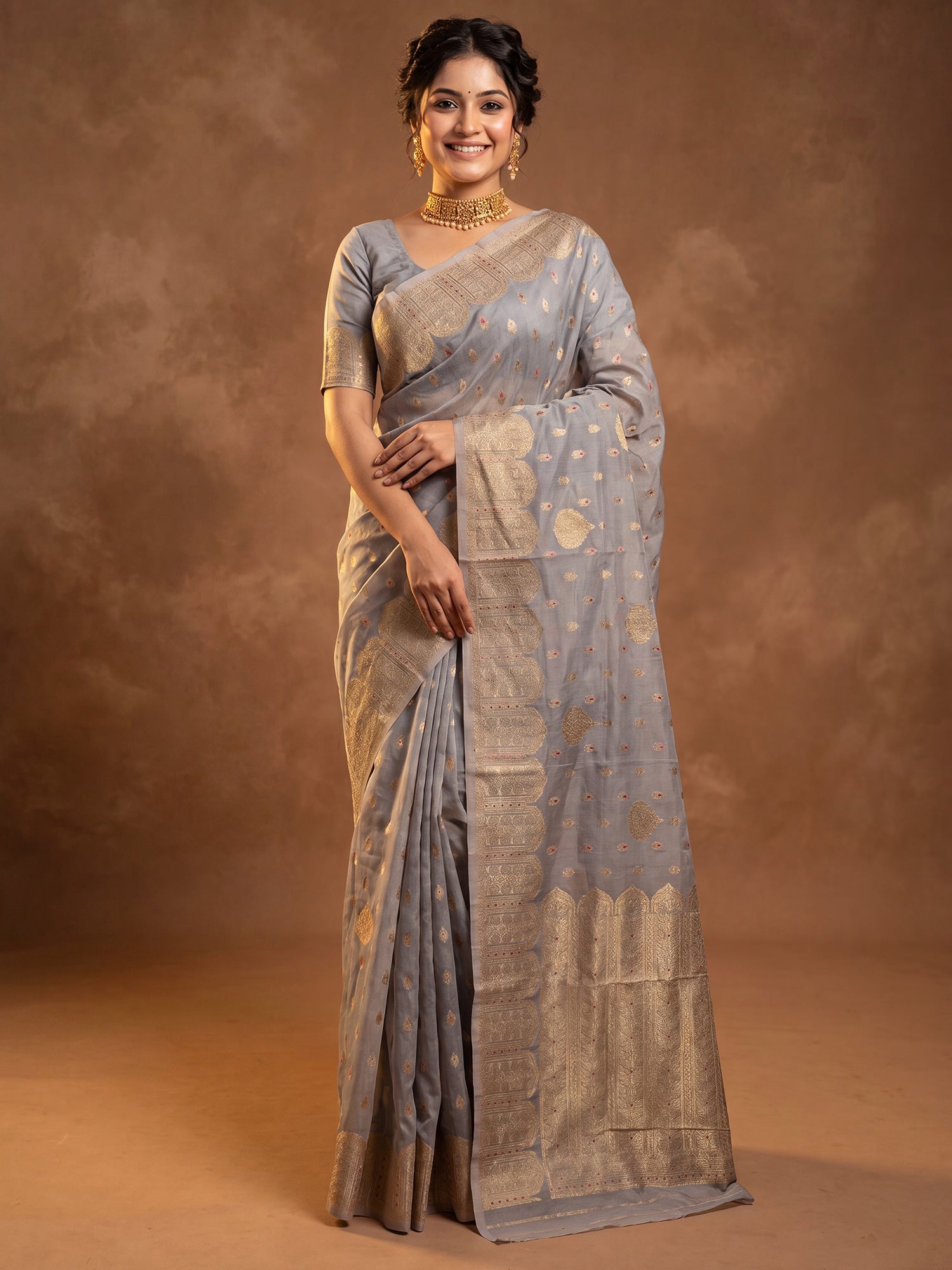 Woman wearing grey silk blend saree with zari butta (metallic motif) work and grey blouse