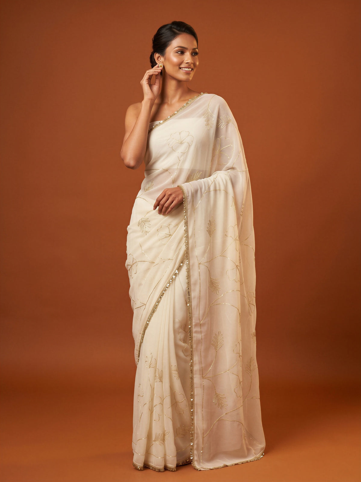 Woman wearing white georgette saree with embroidered motif work and white blouse