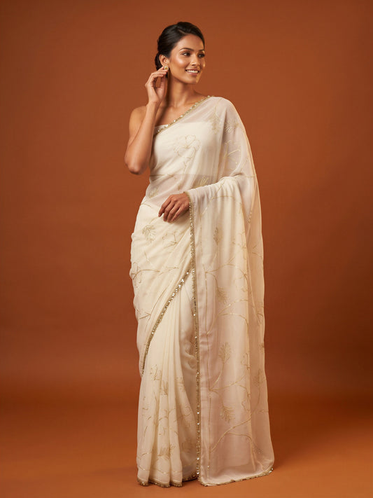 Woman wearing white georgette saree with embroidered motif work and white blouse