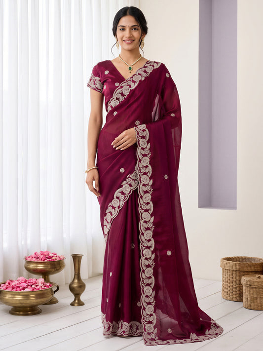 Woman wearing burgundy satin saree with embroidered motif work and burgundy blouse