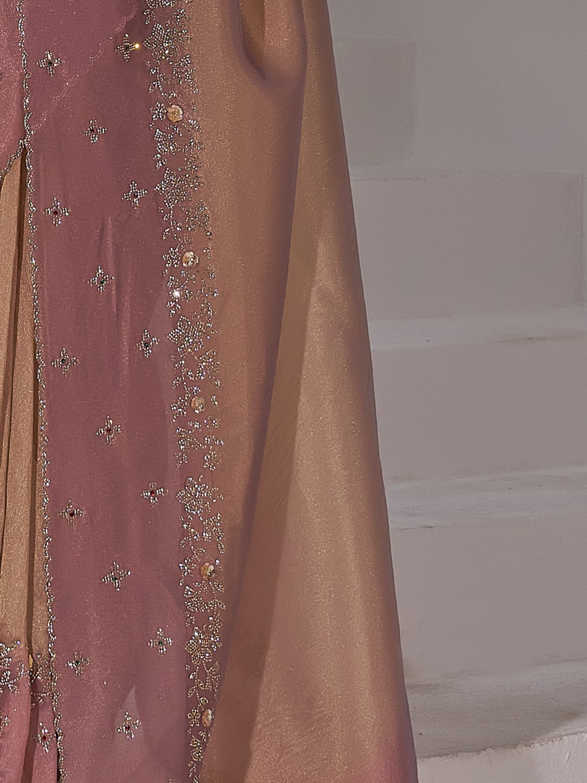 Pallu detail of peach organza saree showing applique design and embellished border