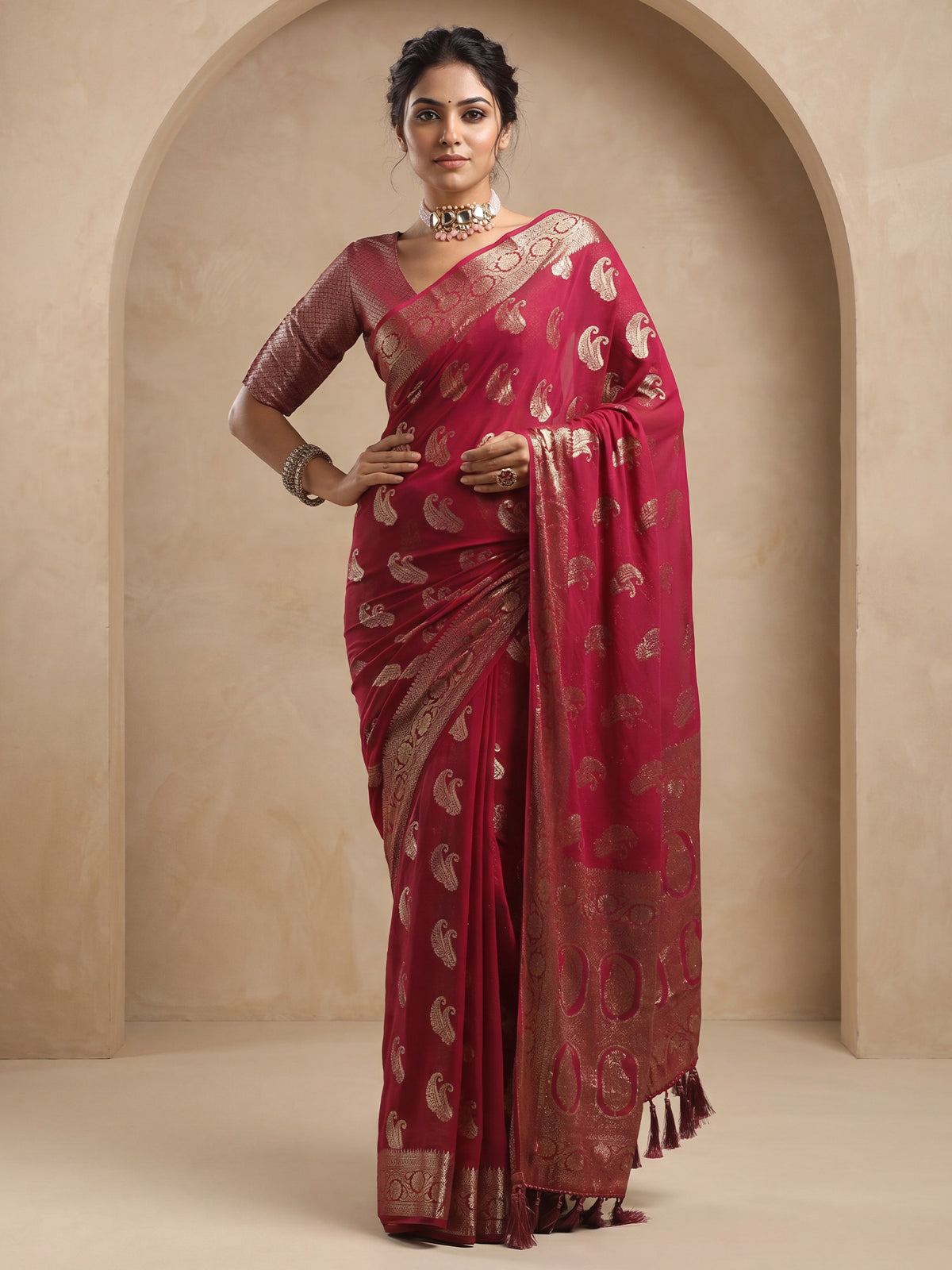 Woman wearing maroon georgette saree with zari butta (metallic motif) work and maroon blouse