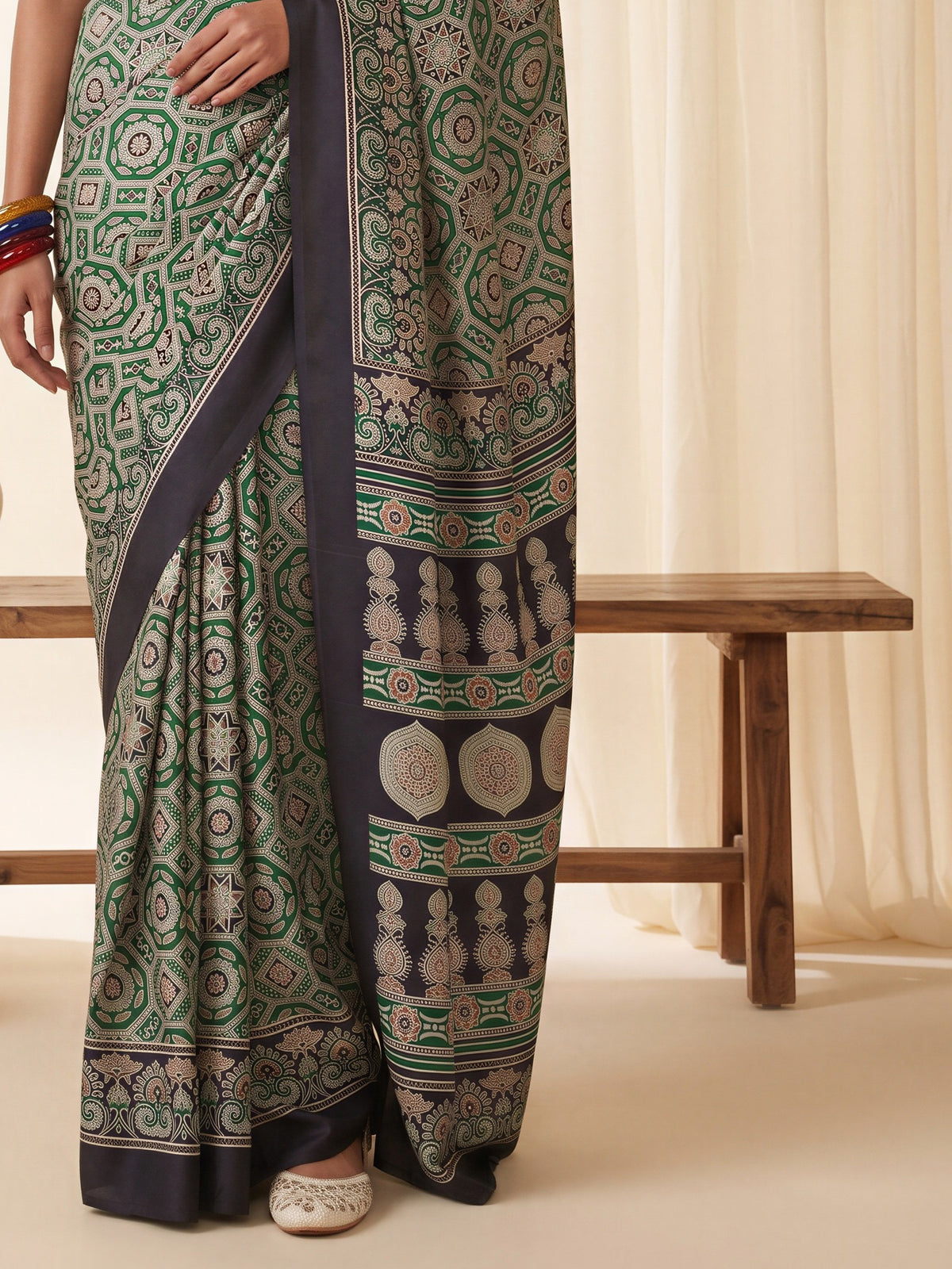 Pallu detail of green crepe saree showing ajrak block-print motif work and printed border