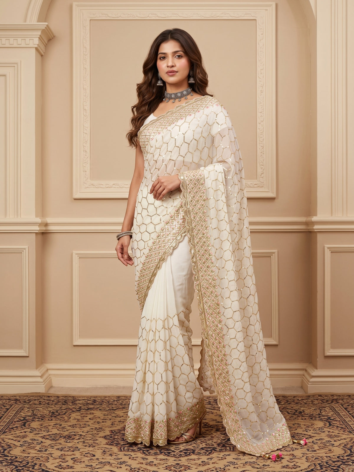 Woman wearing offwhite georgette saree with ornamented surface design and off white blouse