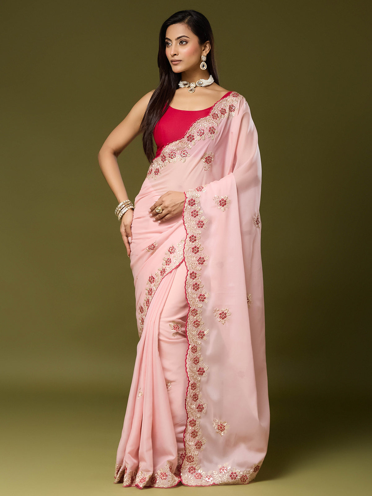 Woman wearing pink georgette saree with embroidered motif work and pink blouse