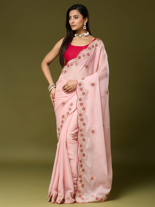 Woman wearing pink georgette saree with embroidered motif work and pink blouse
