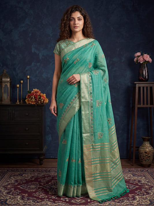 Woman wearing sea green cotton linen saree with embroidered motif work and sea green blouse