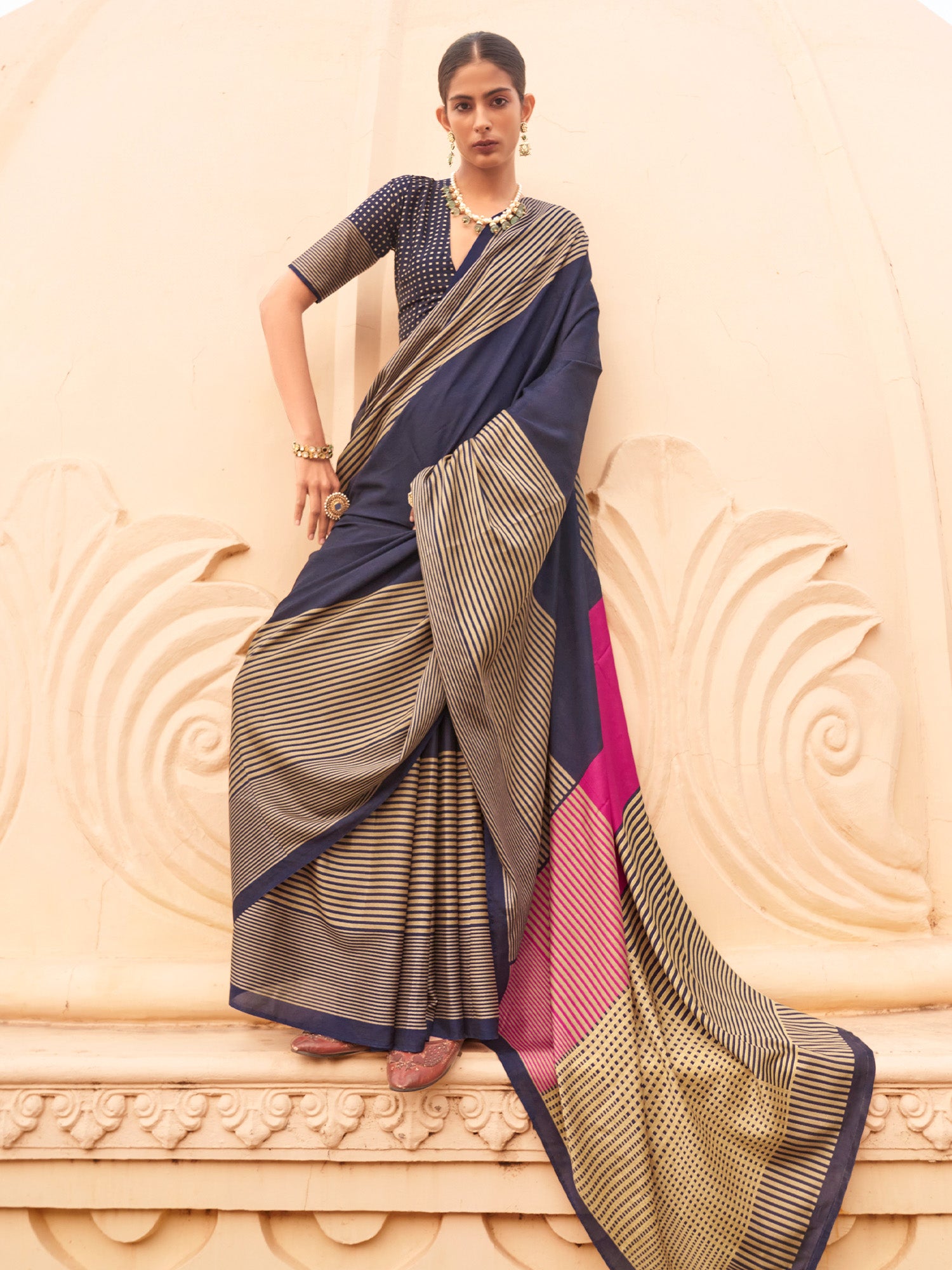 Woman wearing navy blue silk blend saree with striped pattern design and navy blue blouse