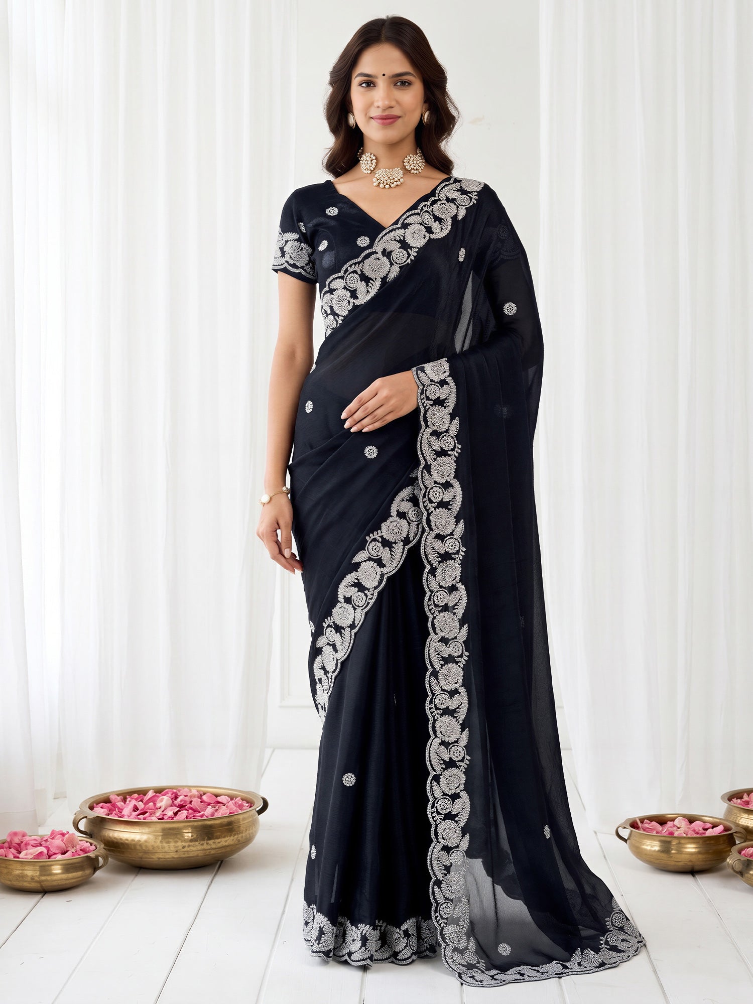 Woman wearing black satin saree with embroidered motif work and black blouse