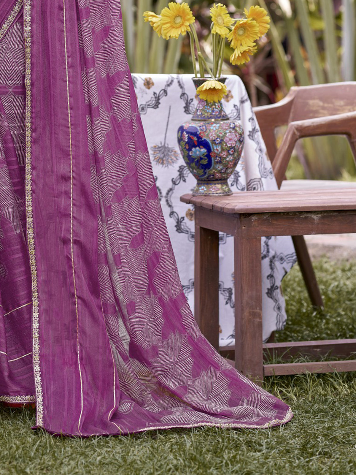 Pallu detail of mauve chiffon saree showing traditional indian motif work and embellished border