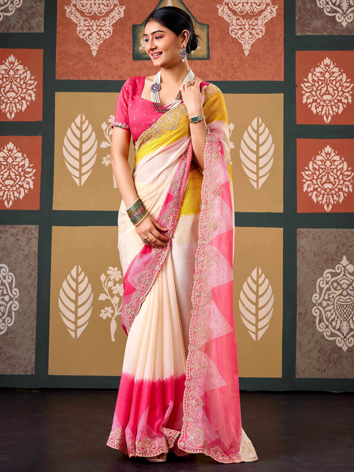Woman wearing cream chiffon saree with bandhani tie-dye dot work and pink blouse