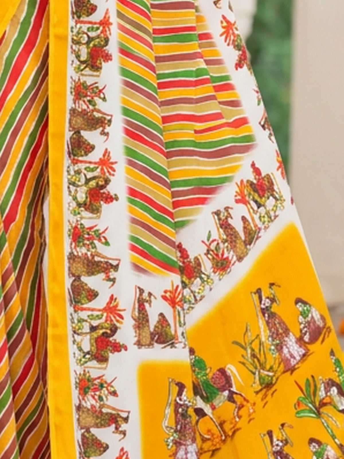 Pallu detail of yellow crepe saree showing striped pattern design and printed border