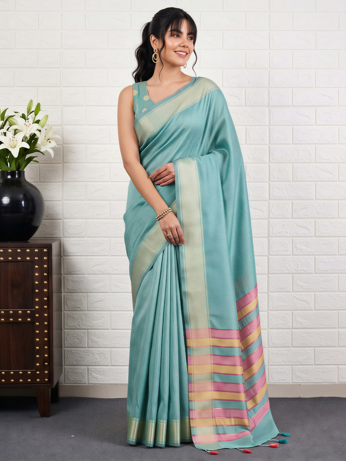 Woman wearing turquoise bhagalpuri silk saree with traditional indian motif work and turquoise blouse
