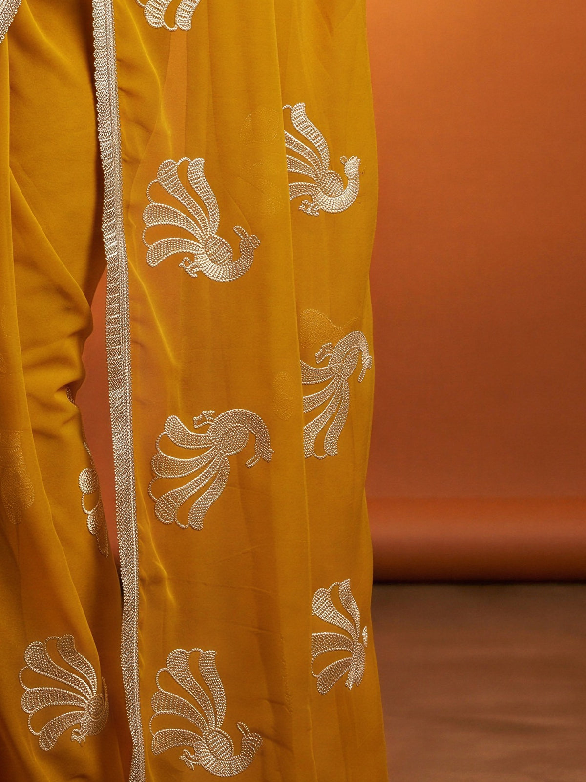 Pallu detail of mustard georgette saree showing embroidered motif work and embellished border