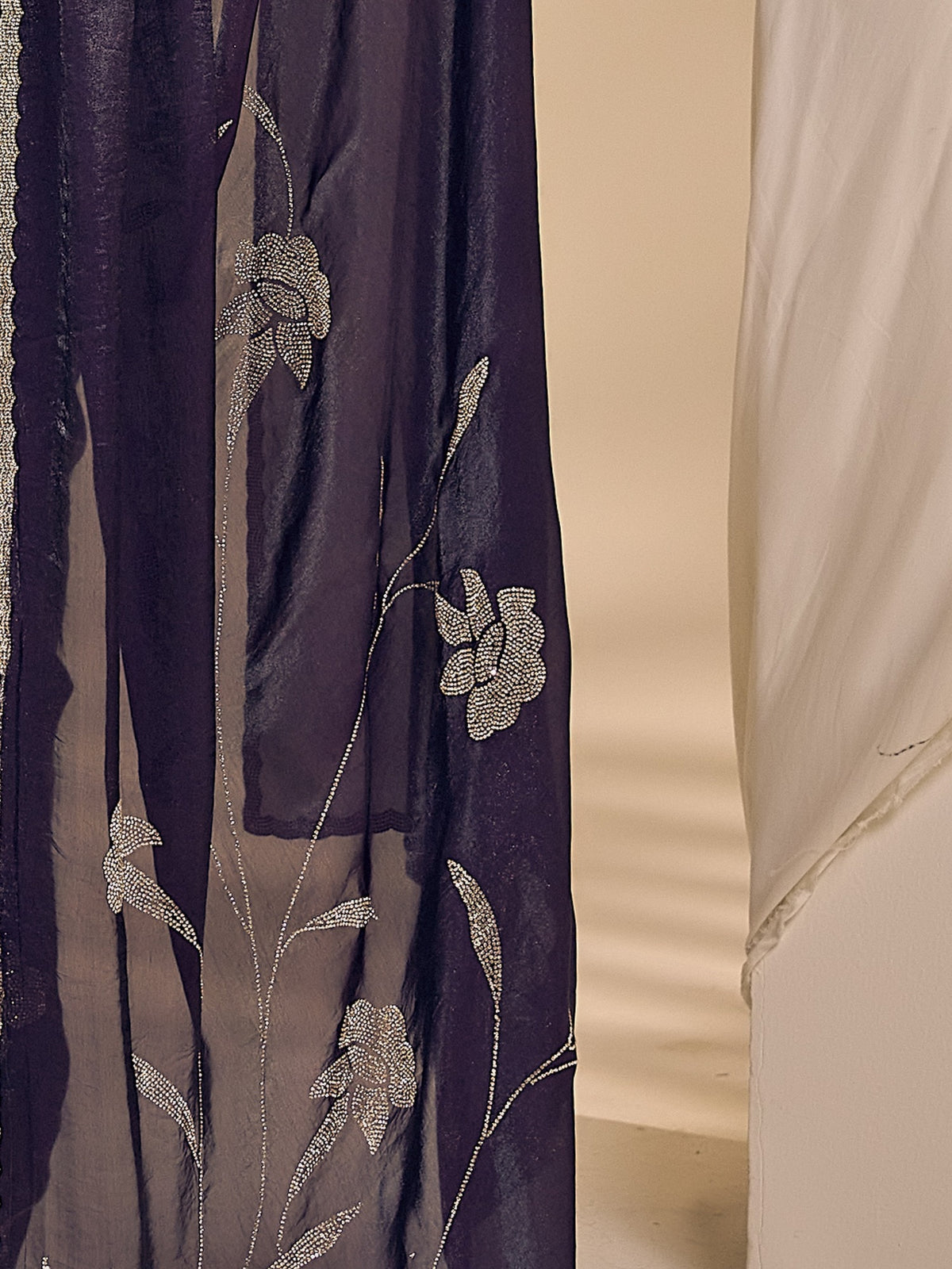 Pallu detail of purple satin silk saree showing ornamented surface design and embellished border