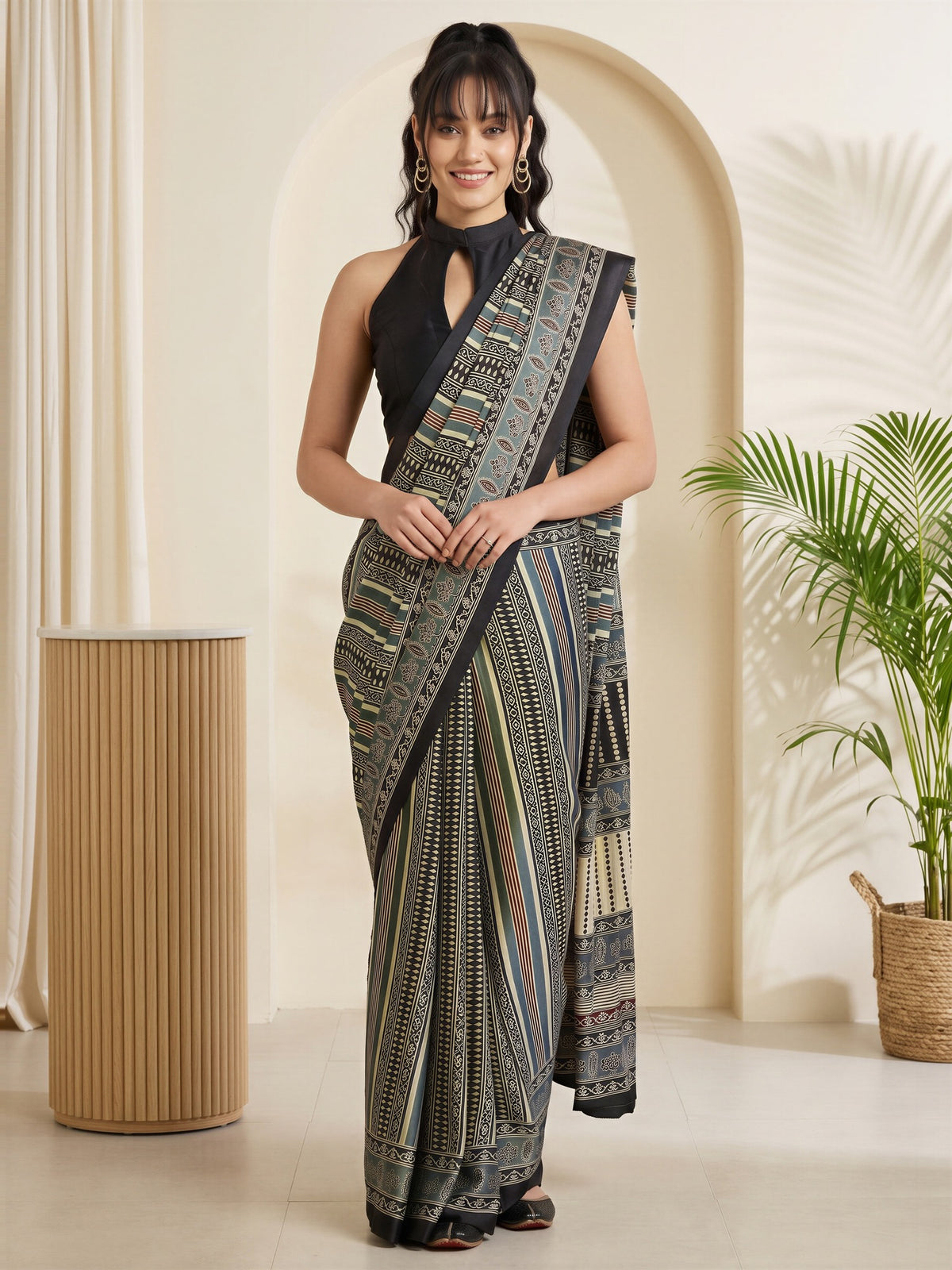 Woman wearing grey satin saree with traditional indian motif work and black blouse