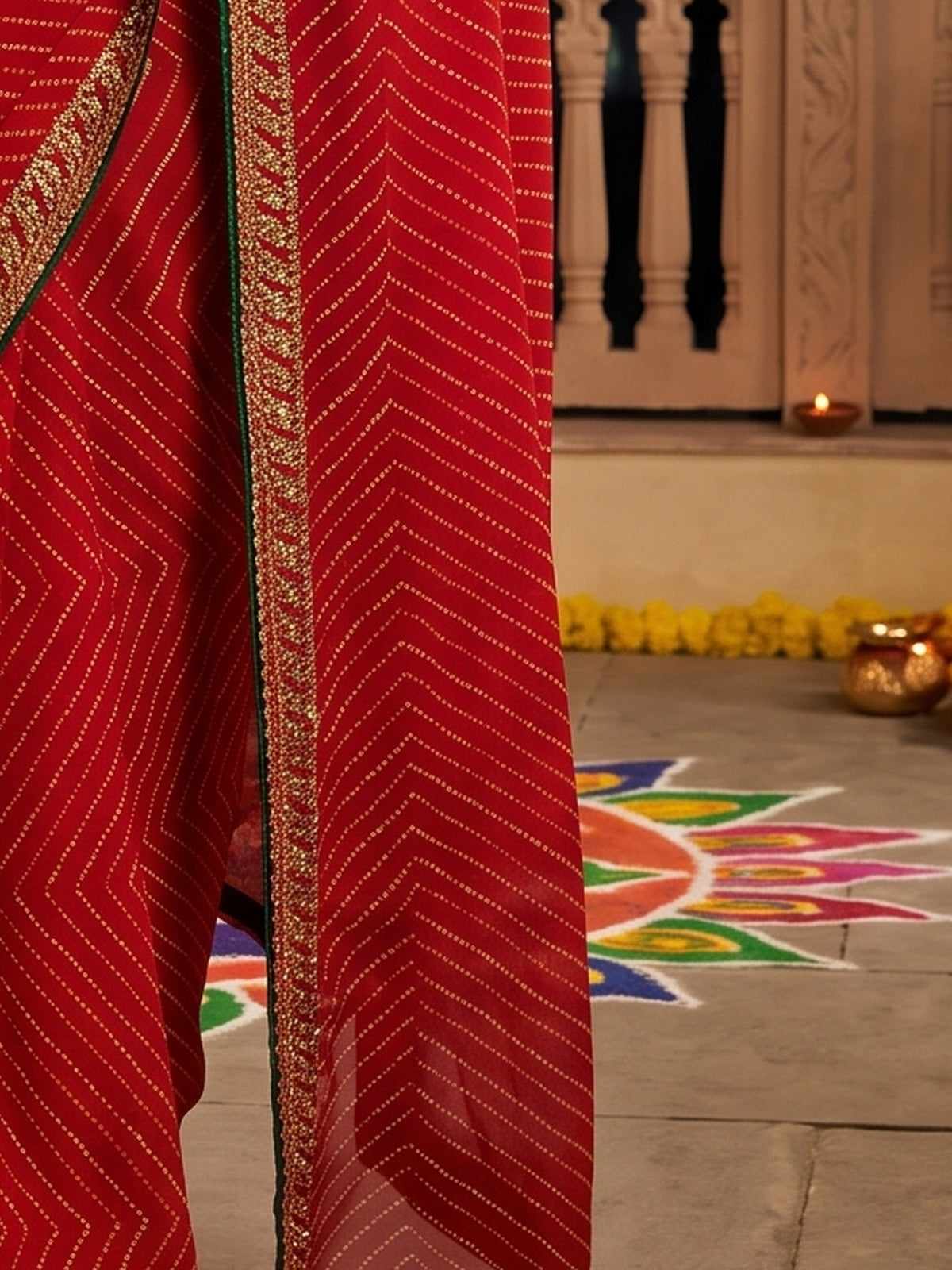 Pallu detail of red georgette saree showing striped pattern design and zari border