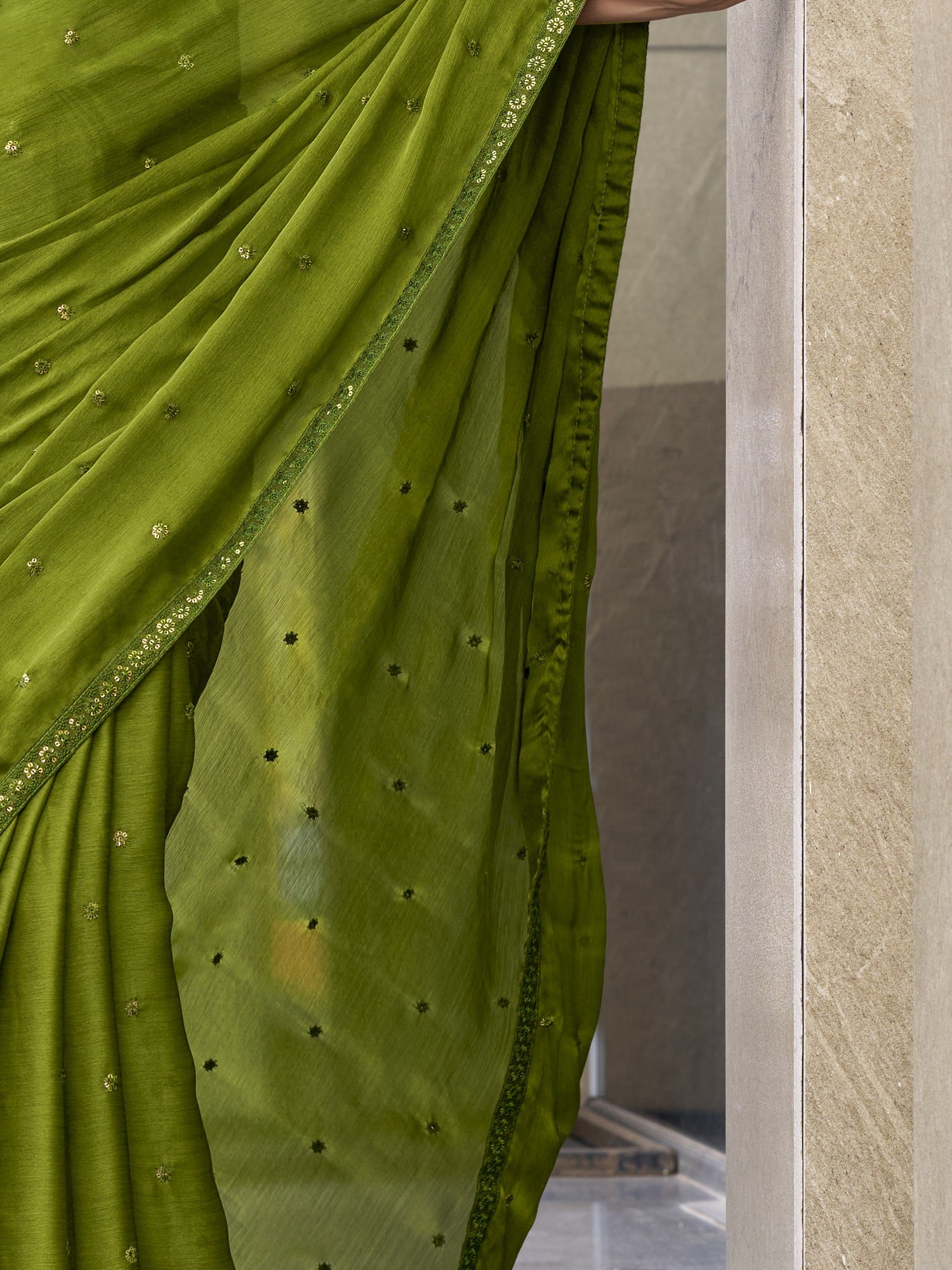 Pallu detail of green satin silk saree showing ornamented surface design and embellished border