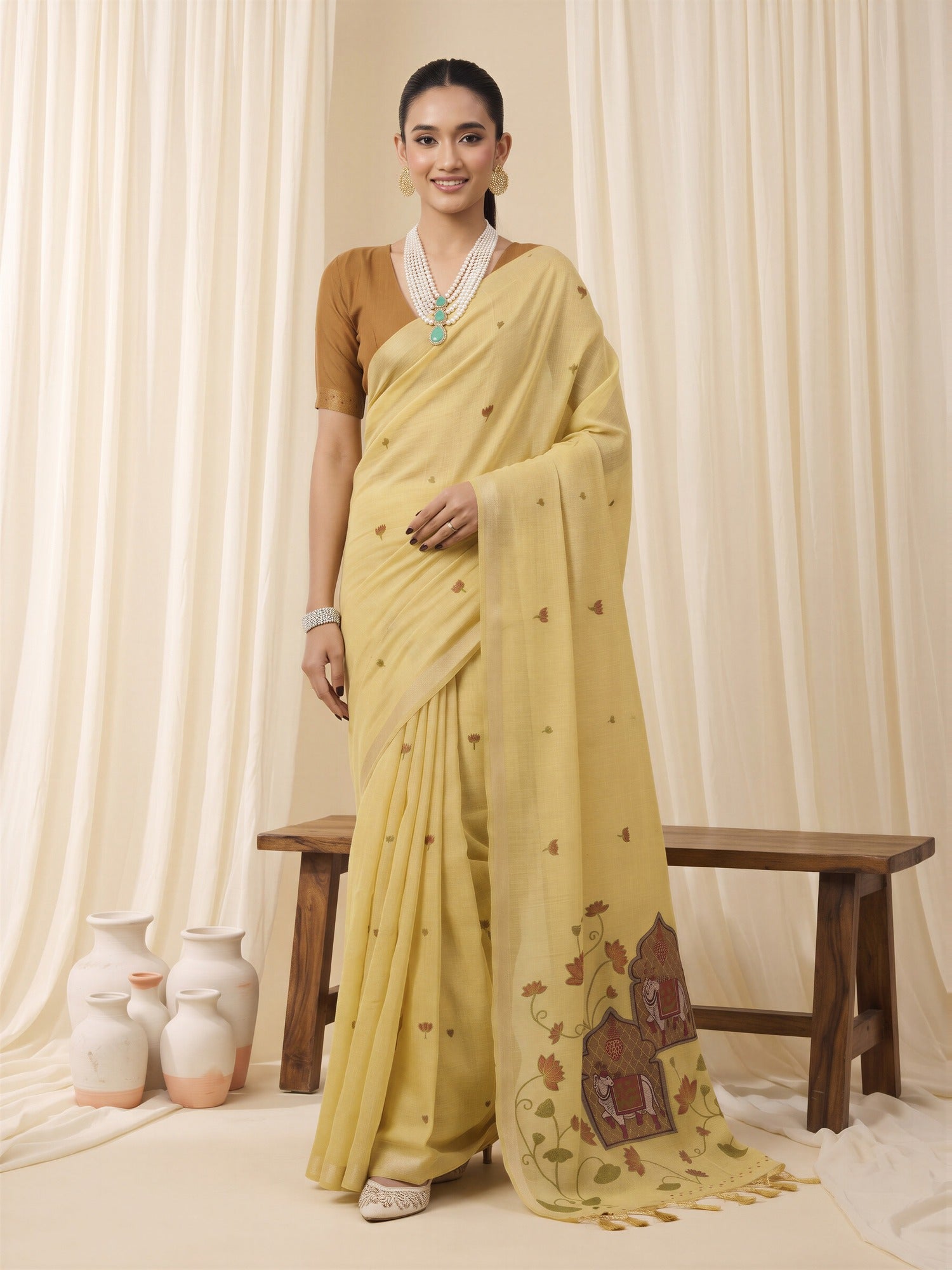 Woman wearing yellow pure cotton saree with traditional indian motif work and mustard blouse
