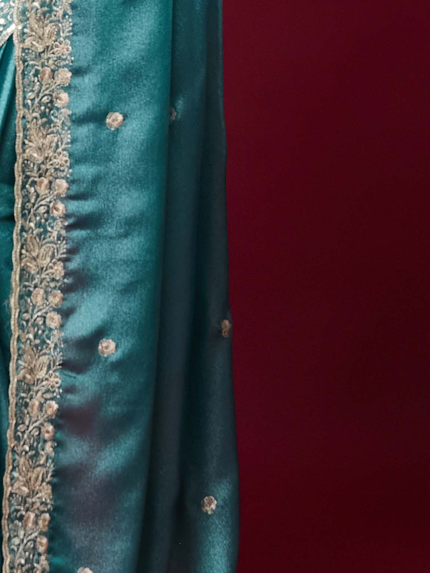Pallu detail of teal blue chinnon saree showing embroidered motif work and scallop border