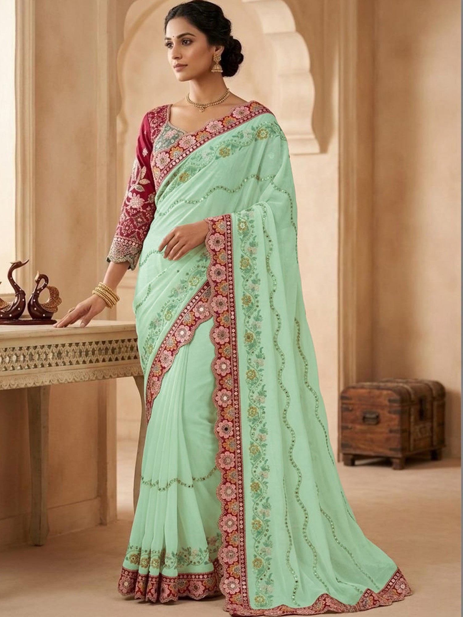 Woman wearing light green pure georgette saree with all-over floral design and pink blouse