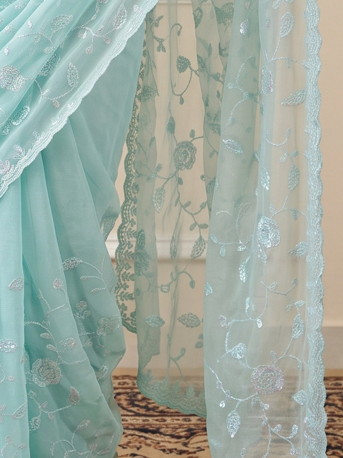 Pallu detail of light blue georgette saree showing ornamented surface design and embellished border