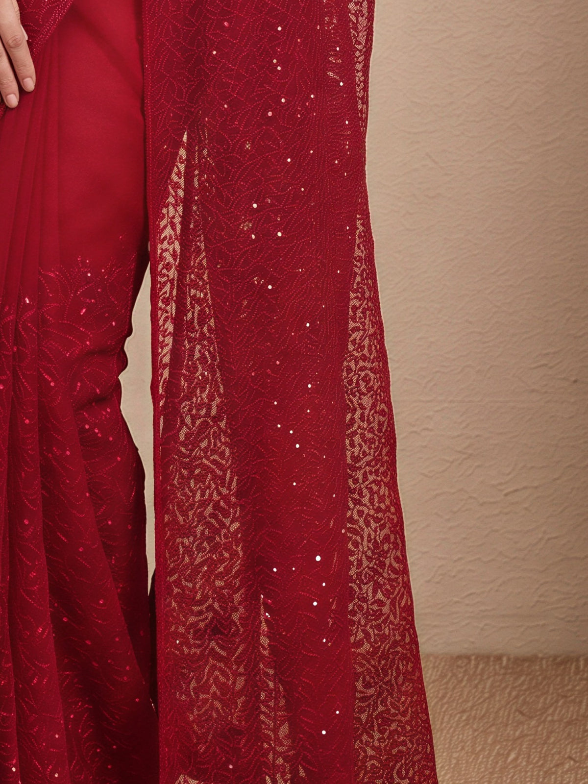 Pallu detail of maroon net saree showing embroidered motif work and embellished border