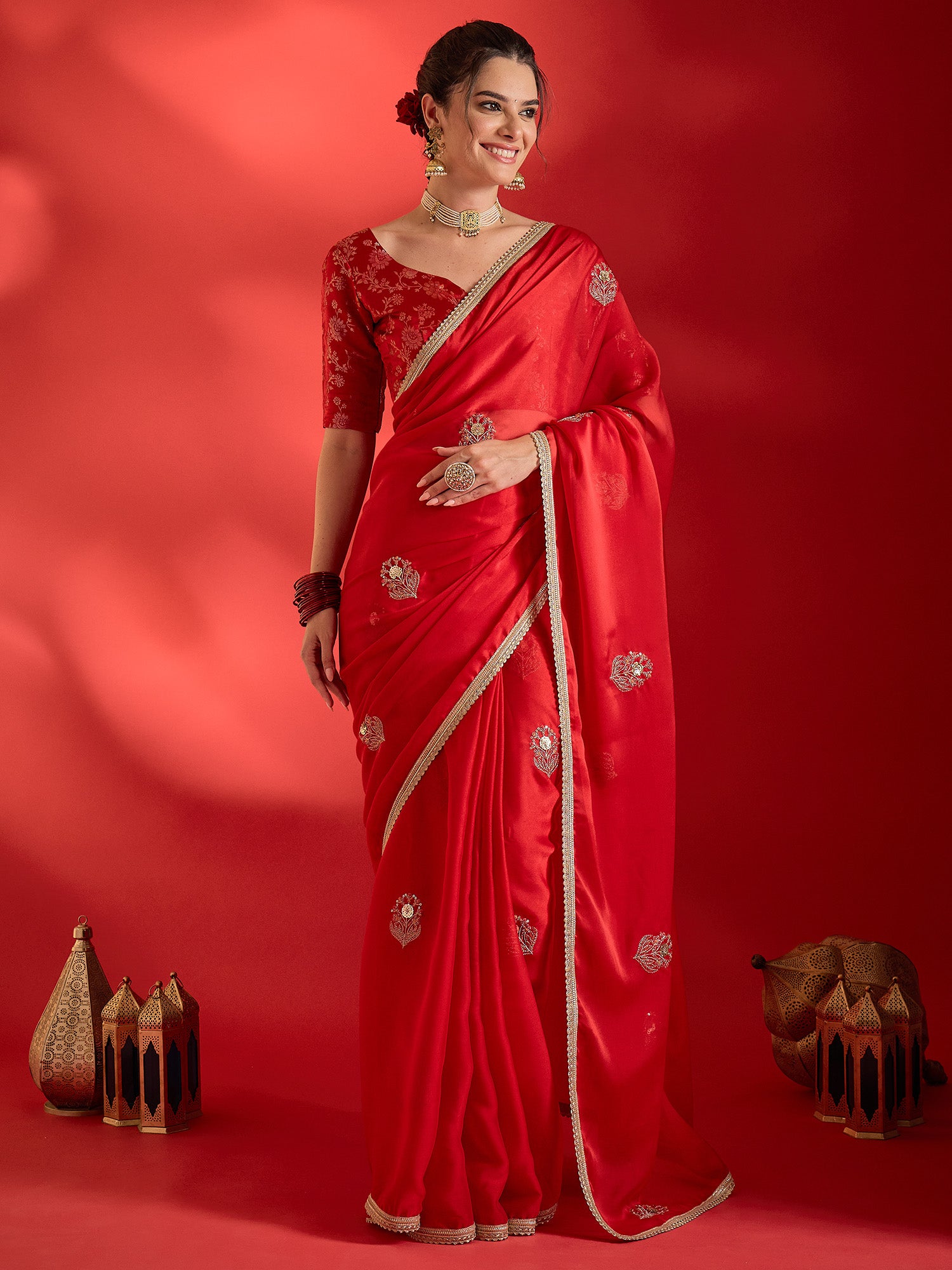 Woman wearing red pure georgette saree with ornamented surface design and red blouse