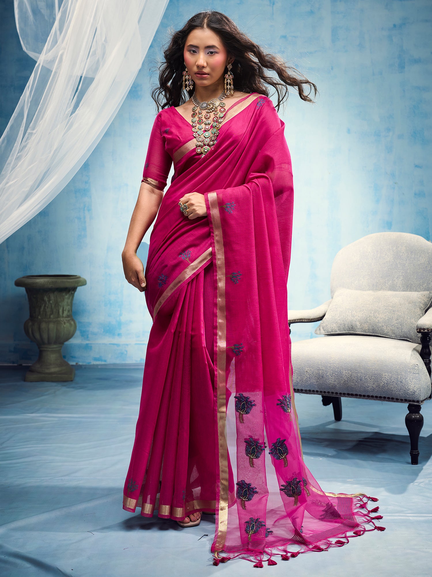 Woman wearing pink muga cotton saree with embroidered motif work and pink blouse