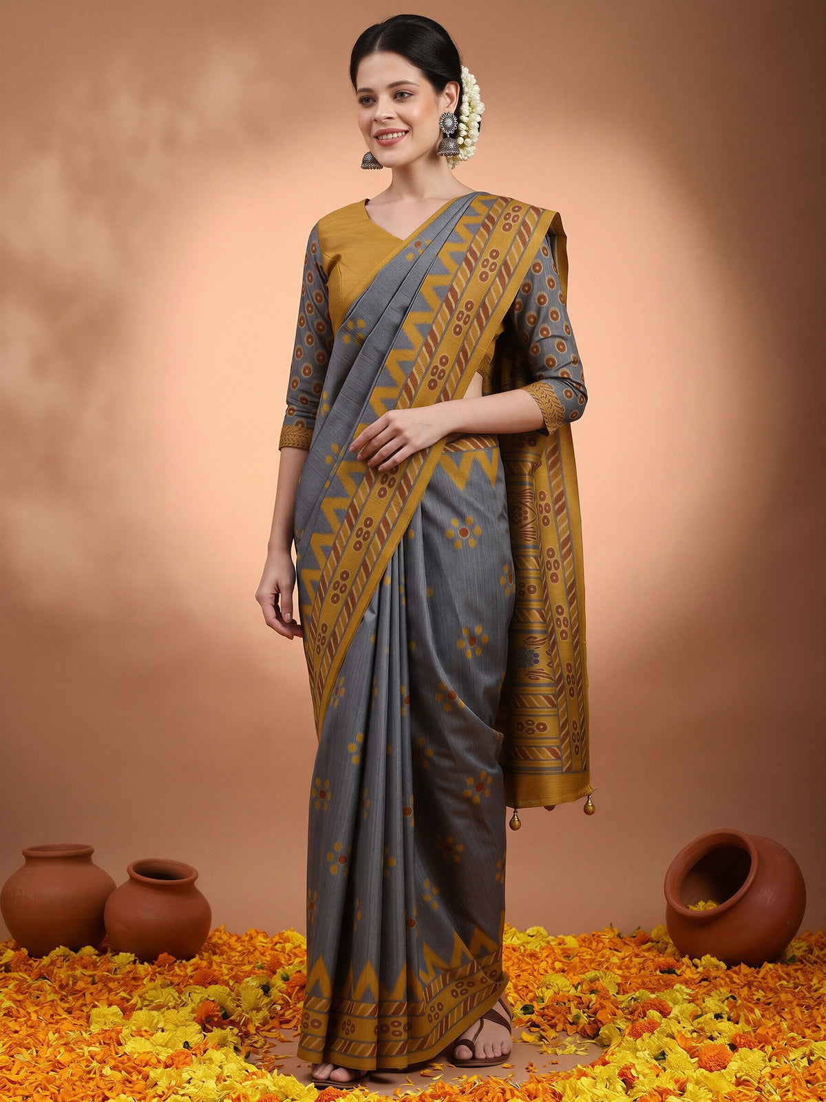 Woman wearing charcoal grey silk blend saree with ikat resist-dyed pattern and mustard blouse