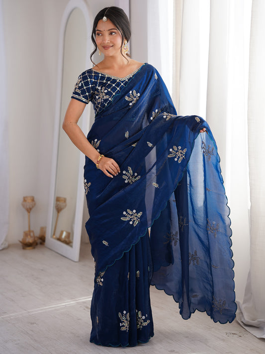 Woman wearing navy blue satin saree with ornamented surface design and navy blue blouse