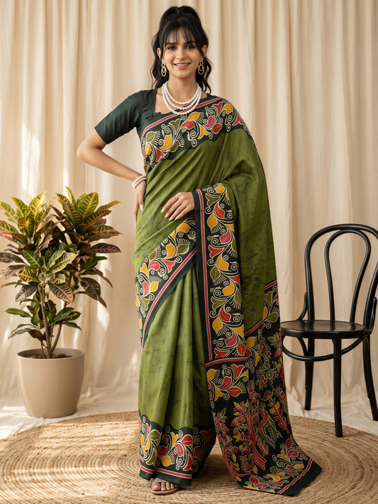 Woman wearing green cotton blend saree with batik wax-resist design and dark green blouse