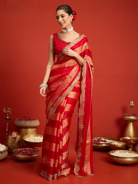 Woman wearing red satin silk saree with ornamented surface design and red blouse