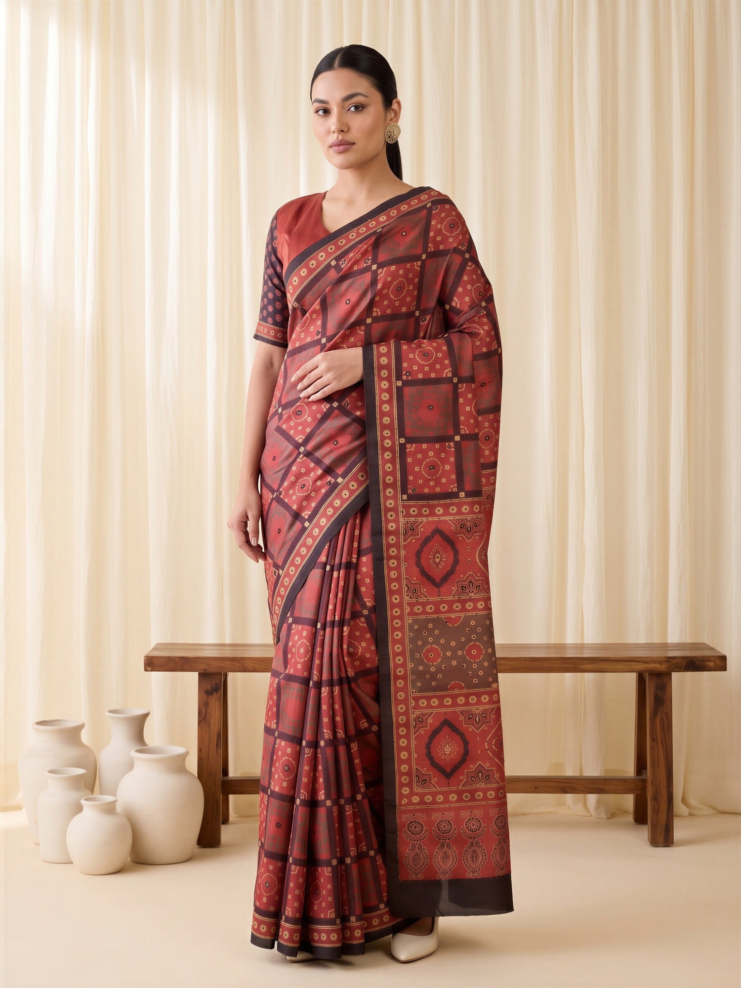 Woman wearing maroon silk blend saree with ajrak block-print motif work and maroon blouse