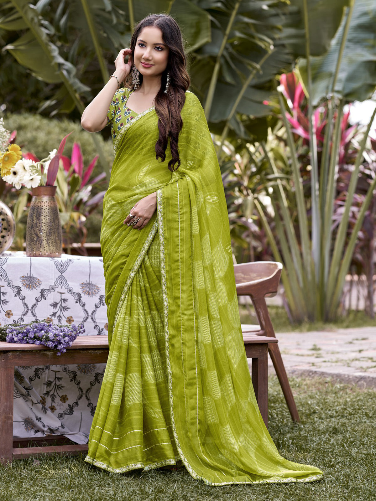 Woman wearing lime green chiffon saree with traditional indian motif work and lime green blouse