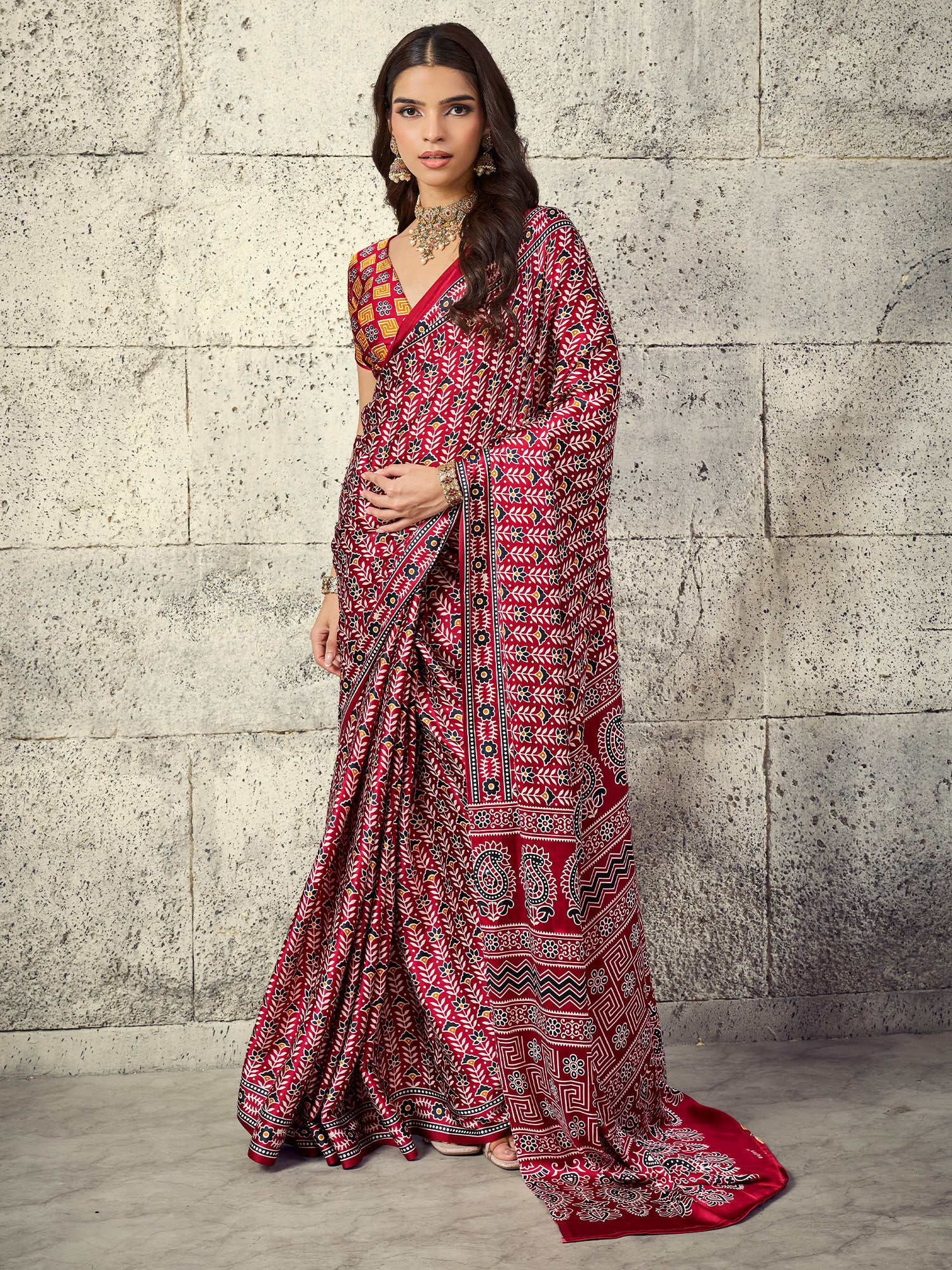 Woman wearing maroon satin saree with ajrak block-print motif work and rust blouse