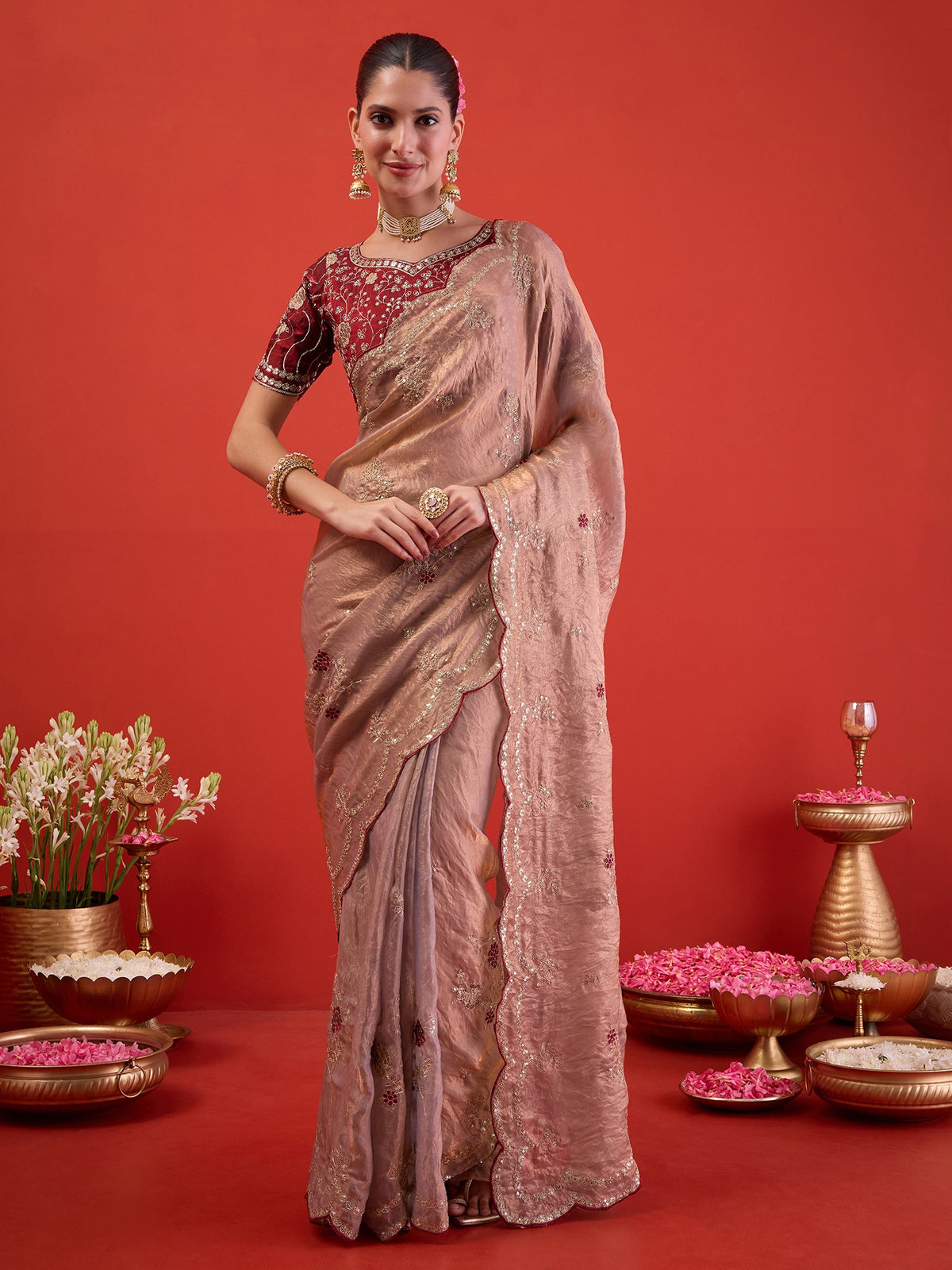 Woman wearing metallic satin silk saree with ornamented surface design and magenta blouse