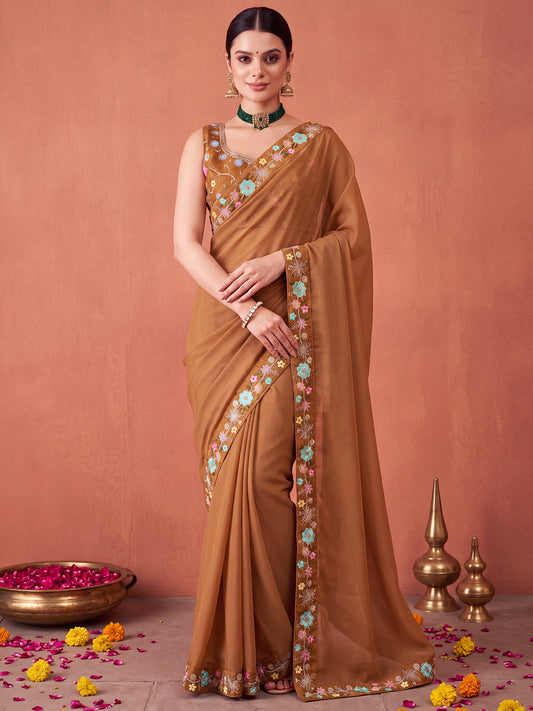 Woman wearing light brown poly georgette saree with embroidered motif work and light brown blouse