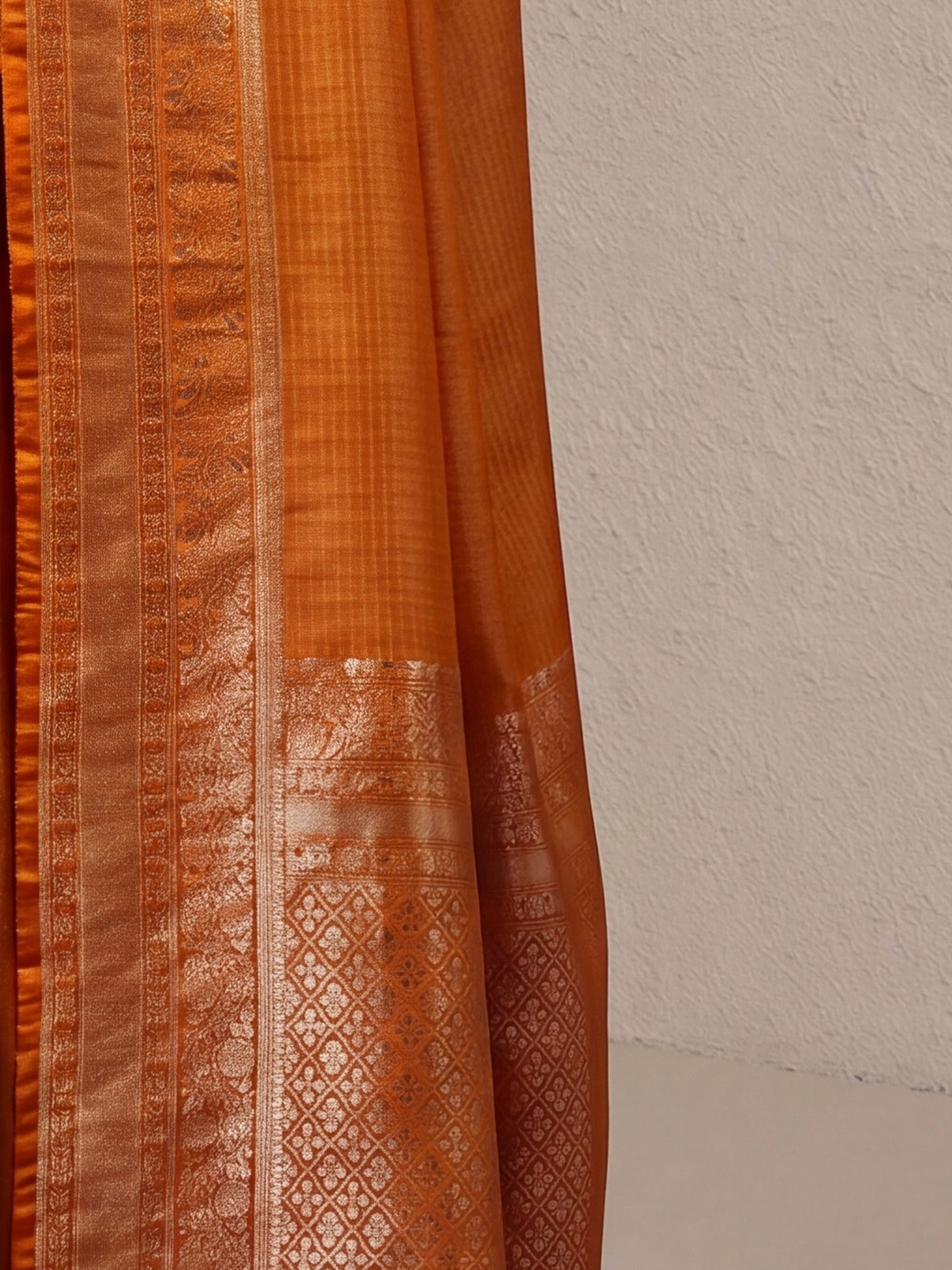 Pallu detail of mustard banarasi silk saree showing checked pattern design and zari border